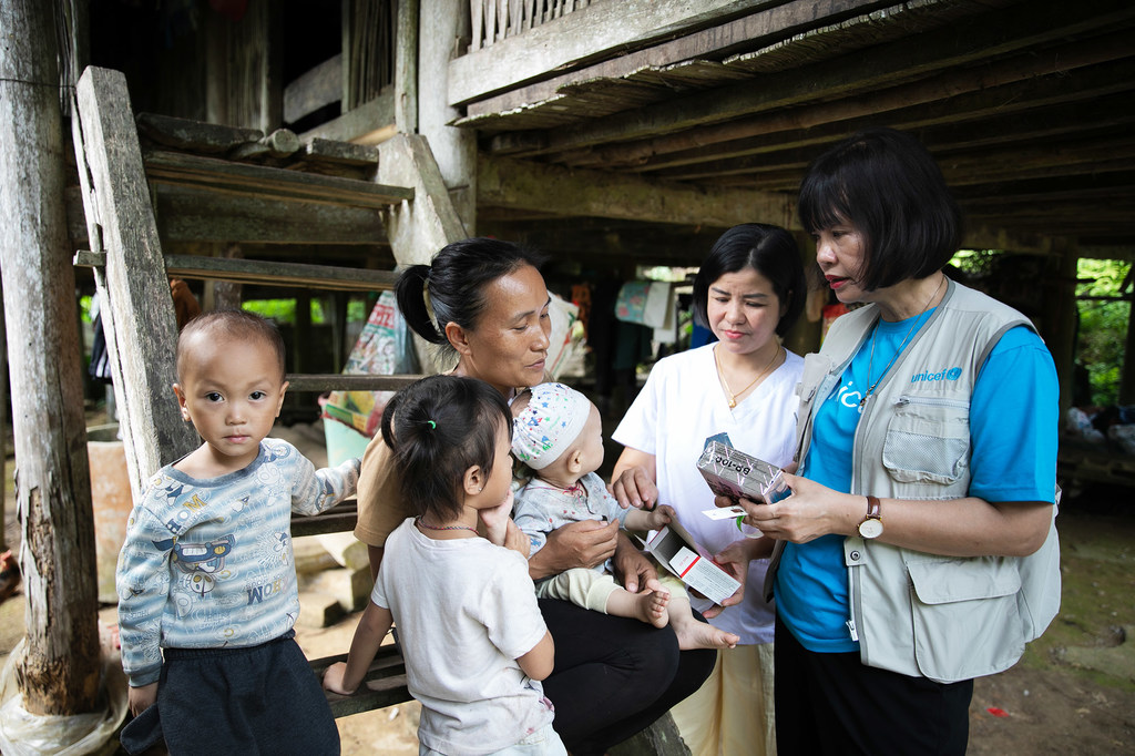 A family in Tuyên Quang province in Viret Nam is provided with nutritional supplements by a UNICEF worker.